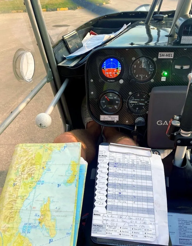 Cockpit of a ZRP light sport aircraft with flight log and aeronautical chart of Zanzibar